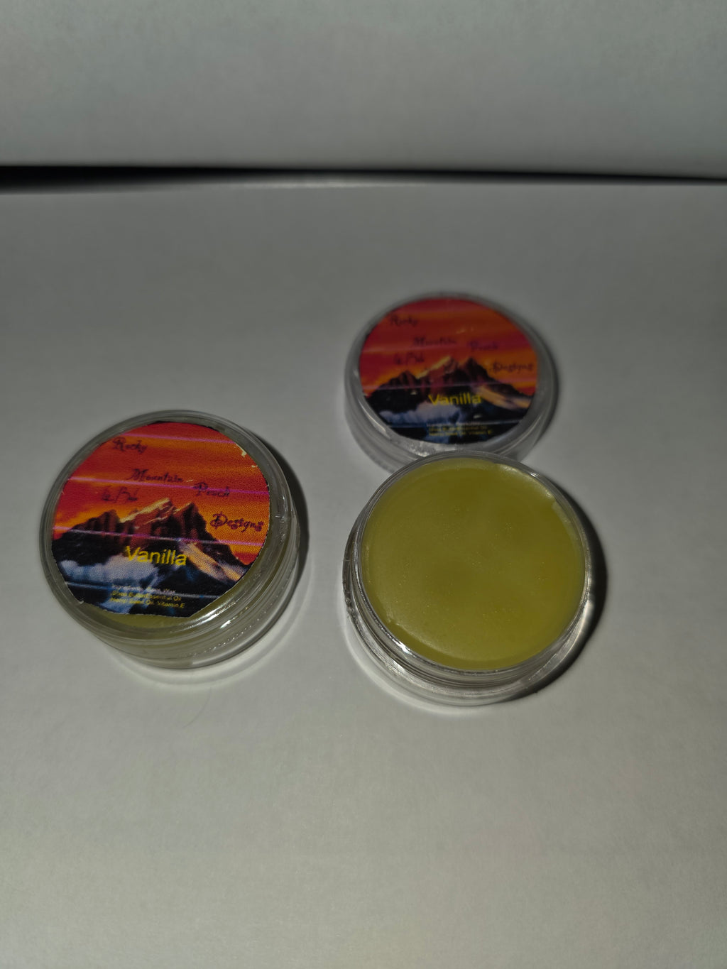 Vanilla lip balm round containers showing the label and balm inside an open container