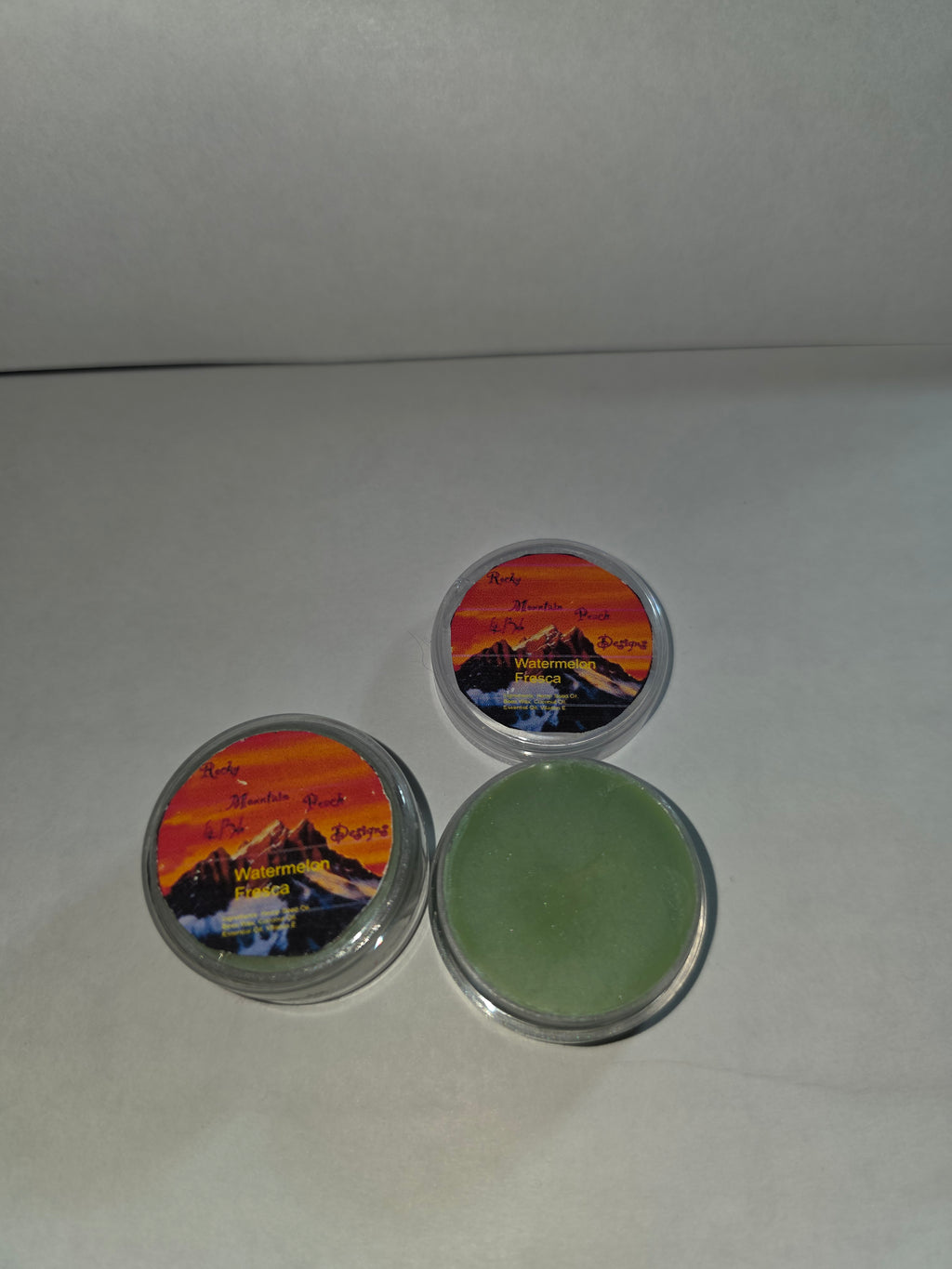 Watermelon Fresca Lip Balm canisters with an open canister showing the balm