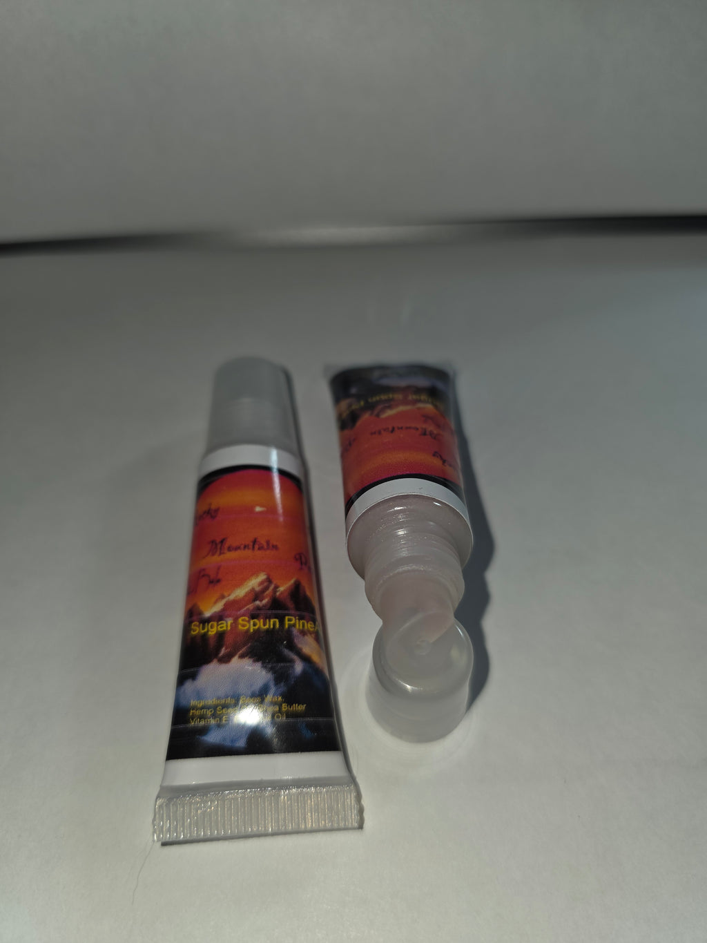 Sugar Spun Pineapple Lip Balm squeeze tubes showing capped and open packaging